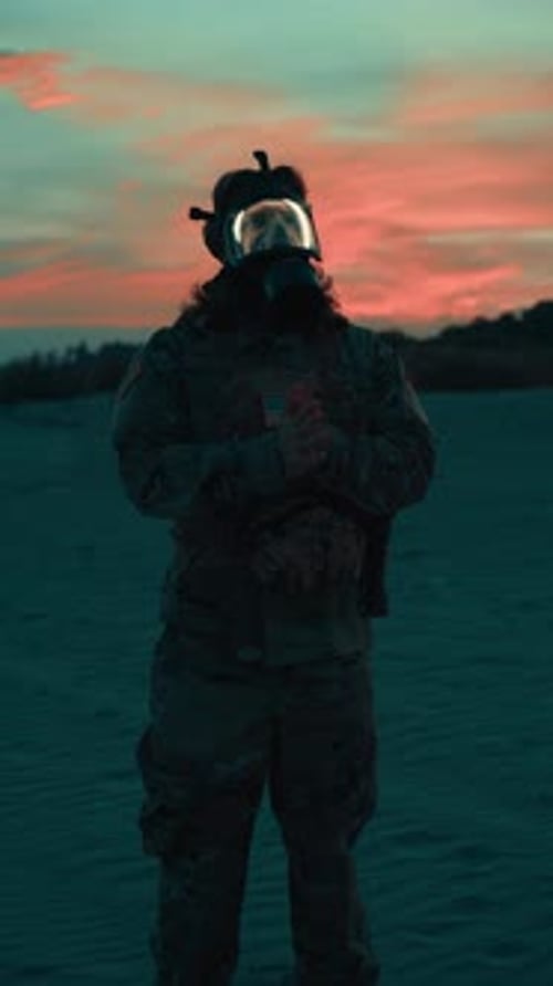American Soldier Wearing a Gas Mask on the Beach at Sunset Ready Surveillance