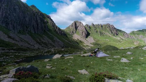 männlicher Wanderer baut Einzelzelt zum Campen im Bergtal auf, Zeitraffer