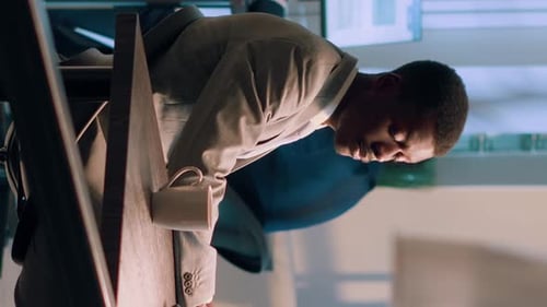 Smiling Man Working at Office Desk, Vertical Video