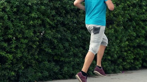 Young man jogging alone in city park super slow motion training session