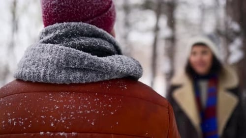 Young Loving Woman Walks From Defocus and Hug Her Partner Smiling in a Park on Snowfall Romantic