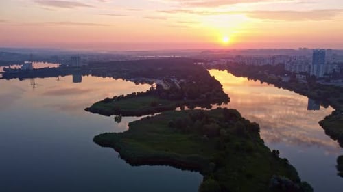Aerial tilt footage of sunrise on river in city