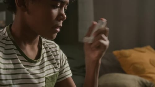 Young Boy Using Inhaler to Prevent Asthma Attack