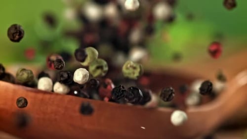Falling Colorful Peppercorns Landing in Wooden Spoon