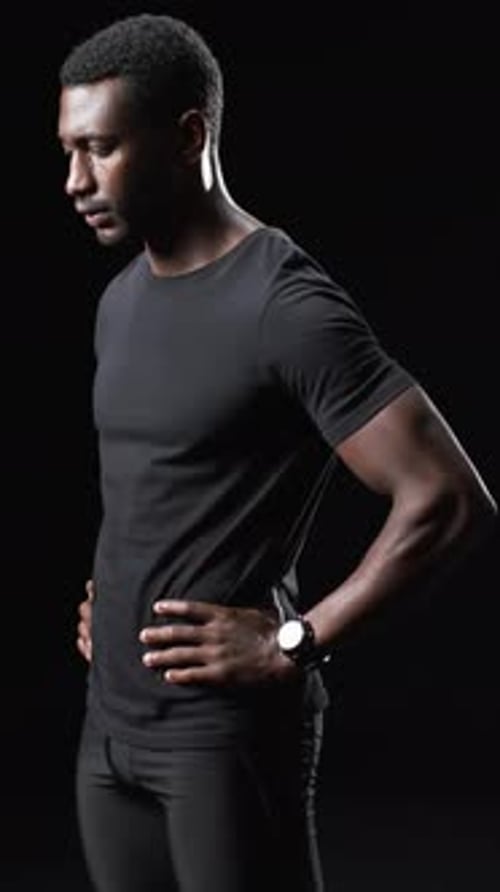 Man Posing in Black T-Shirt in Dark Environment