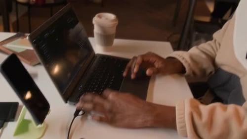 Black Male Software Developer Coding on Laptop in Night Office