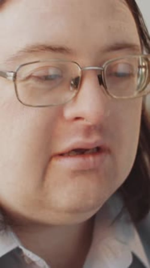 Vertical of Curious Man with Down Syndrome Spinning Globe Studying Continents