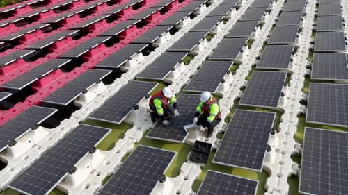 Schwimmendes Solarpanel auf dem Teich. Der Arbeiter wartet und überprüft schwimmende Photovoltaikmodule.