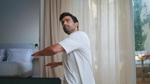 Man Stretching Arms and Shoulders Indoors at Home