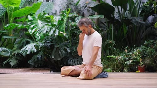 Adult man doing yoga in nature setting