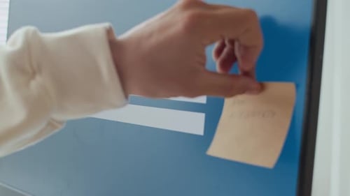 Aufkleber mit Passwortinformationen von Hand auf dem Computerbildschirm anbringen