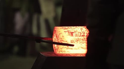 Glowing Hot Metal Block on Anvil Industrial Steel Forging Shaping with Hammer in Dark Workshop