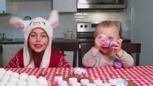 Two Joyful Children Decorate Easter Eggs for the Easter Holiday
