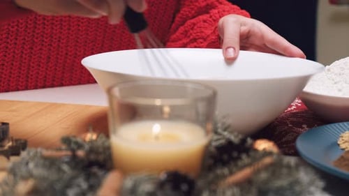 Person mixing ingredients with whisk for festive baking