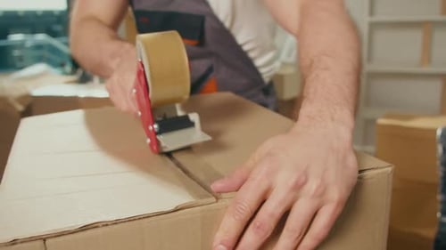 Man Sealing a Box with Tape Dispenser