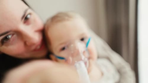 Adult Comforts Toddler Wearing Nebulizer Mask