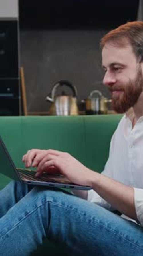 Lächelnder Mann mit Laptop, der E-Mail-Nachrichten checkt oder in sozialen Netzwerken im Internet nach Freunden sucht