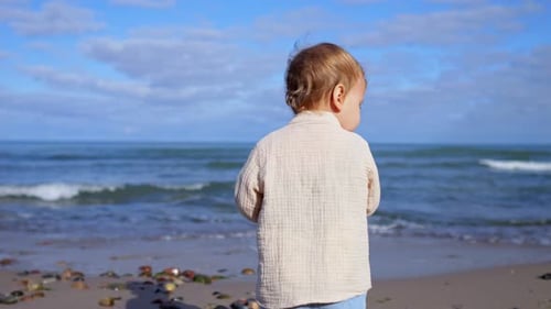 Girl Stands on Beach with Cheerful Smile and Spinning