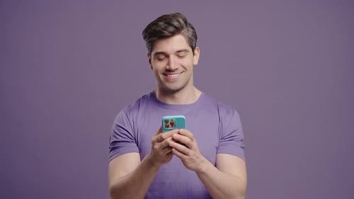 Smiling Man Uses Smartphone on Isolated Background