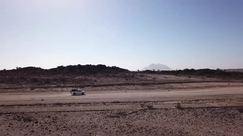 Conducción de automóviles en un camino de ripio en un desierto aéreo