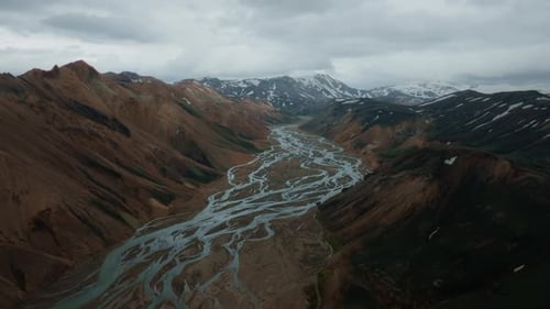 Aerial view of Landmannalaugar mountains with visible river estuary, ice peaks, and clouds. Part 1.
