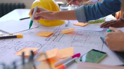 Architects Collaborate Over Blueprint in Bright Office