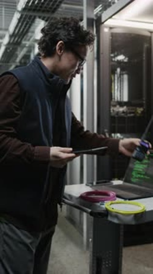 Asian Network Engineer Using Walkie Talkie with Tablet in Data Center