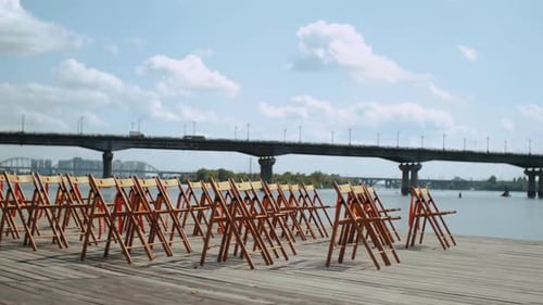 Wedding Decoration Wooden Chairs on the Pontoon Bridge Slow Motion Shot Bridge on the Background