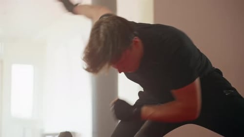 Athlete in Black Sportswear Performs Intense Combat Training Move Inside Gym
