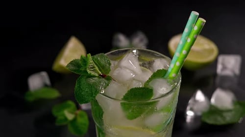 Close-up of Refreshing Mojito Cocktail with lime, ice cubes and green mint leaves