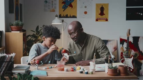 Child and Adult Painting a Solar System Model