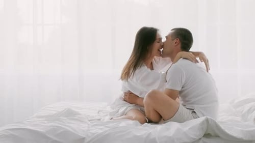 Affectionate Couple Embracing and Kissing in Bed