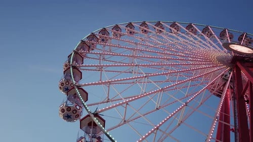Riesenrad-Attraktion, die in der Abenddämmerung im Vergnügungspark leuchtet 4