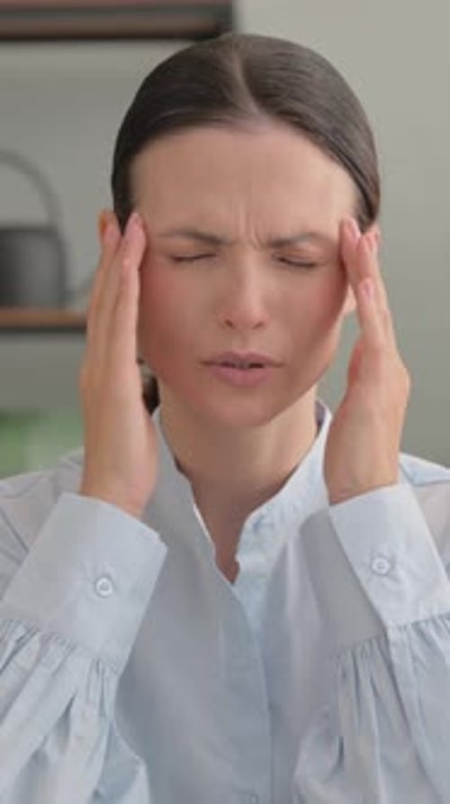 Woman Massaging Temples Due to Headache Pain