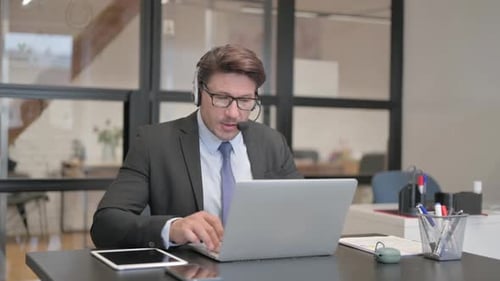 Call Center Man Chatting Online on Laptop with Headset