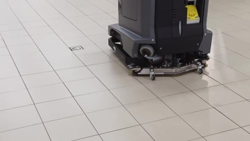 Lavador de piso industrial limpando piso de ladrilho em tempo real, exibindo limpeza profissional