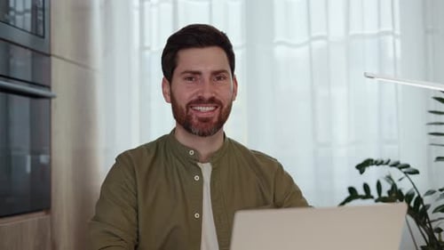 Smiling Man with Laptop Working from Home