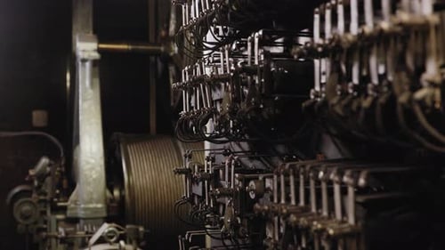 Static view of two wheels of a manual elevator moving in opposite direction in a dark lift room of t