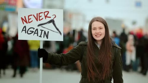 Young Woman Holding Protest Sign At A Rally