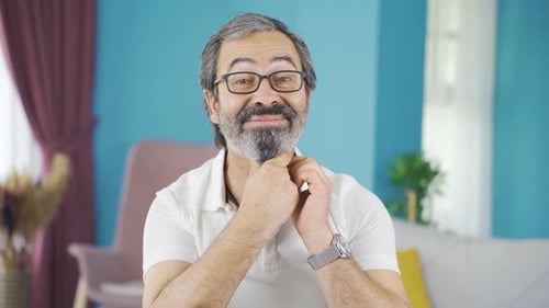 Man With Gray Hair Touches His Face and Laughs