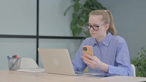 Young Woman Working with Laptop and Smartphone
