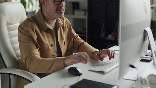 Mature Programmer Typing on Computer