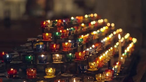 Colorful Candle Stand Enhances Peaceful and Reflective Atmosphere in Dimly Lit Church
