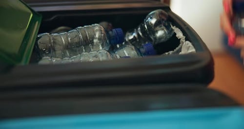 Putting Plastic Bottle in Recycle Bin Close Up