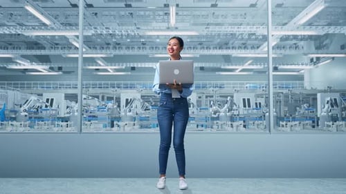 Asia Female Professional Worker Use A Laptop And Looks Around at Factory Digitalization