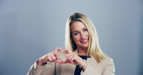 Woman Smiling and Making Heart Shape With Hands