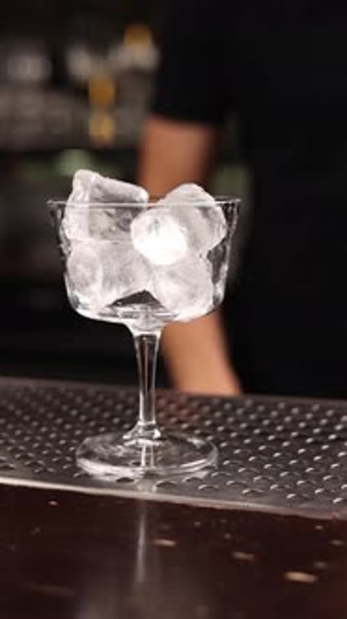 A bartender prepares an alcoholic cocktail at the bar. Close up