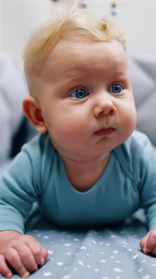 Adorable Baby with Blue Eyes Lying on Stomach