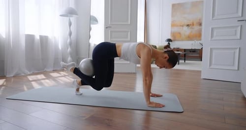 Woman Working Out With a Ball on Yoga Mat