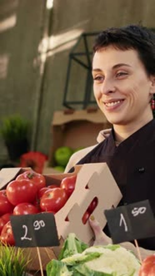 Smiling Woman Holding Tomatoes at a Farmer's Market